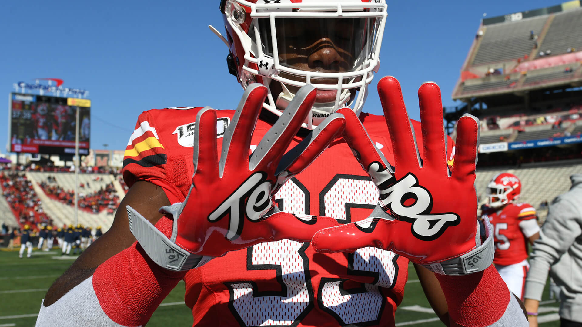 Football player shows Terps script gloves