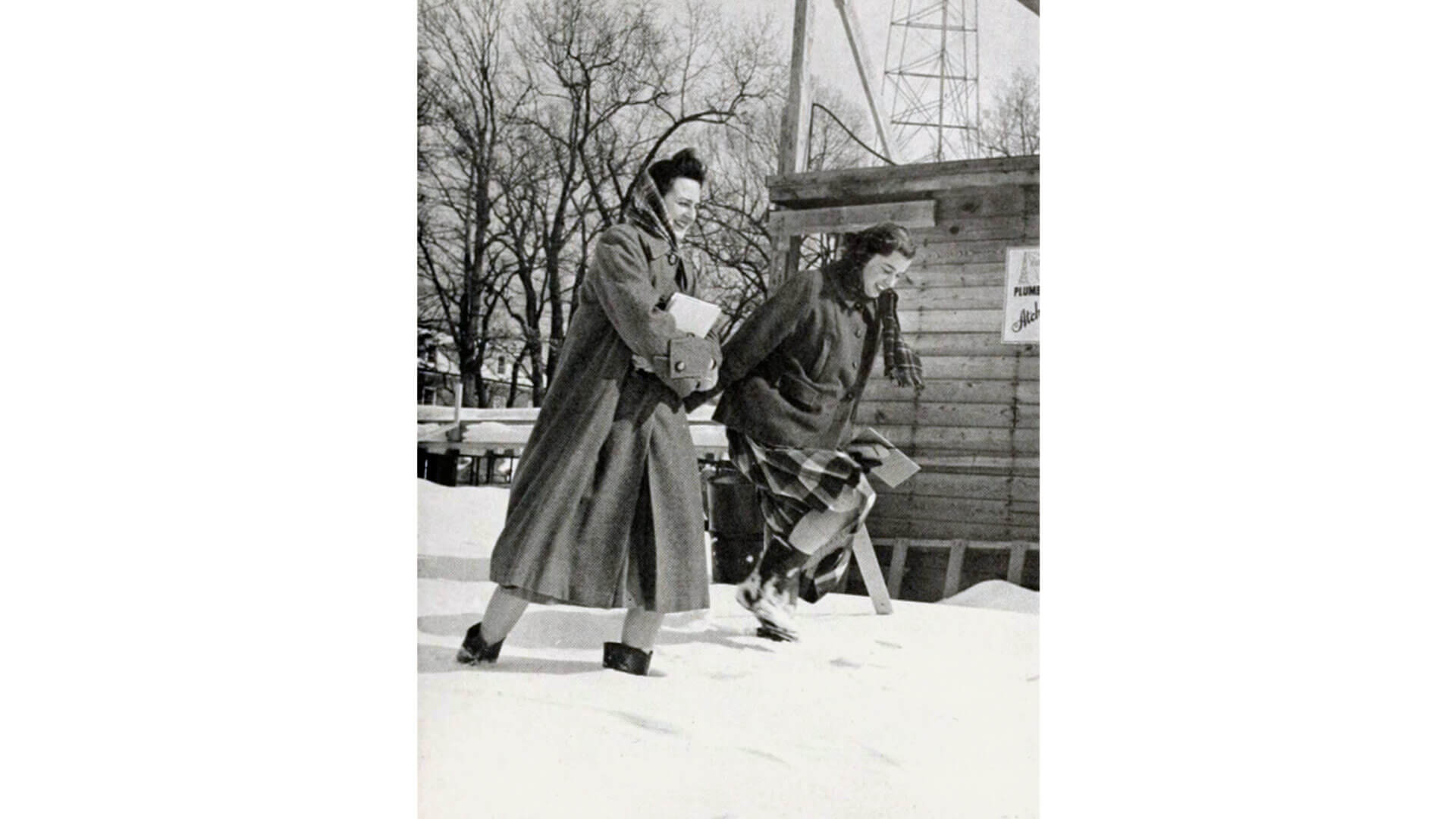 Two students walk in the snow in 1958