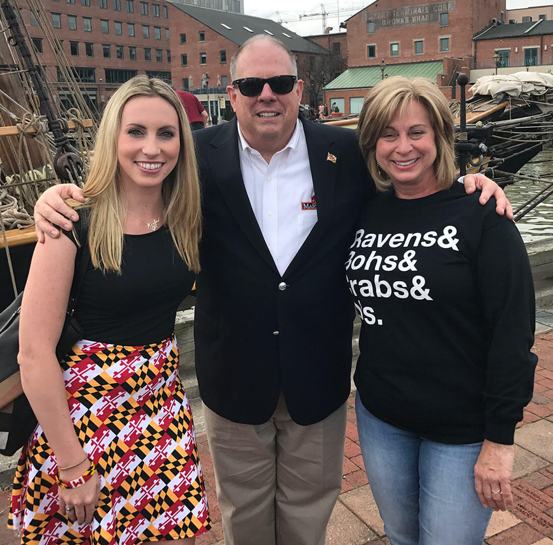 Ali von Paris ’12 with Gov. Larry Hogan and woman wearing shirt that says "Ravens & Bohs & Crabs & O's"