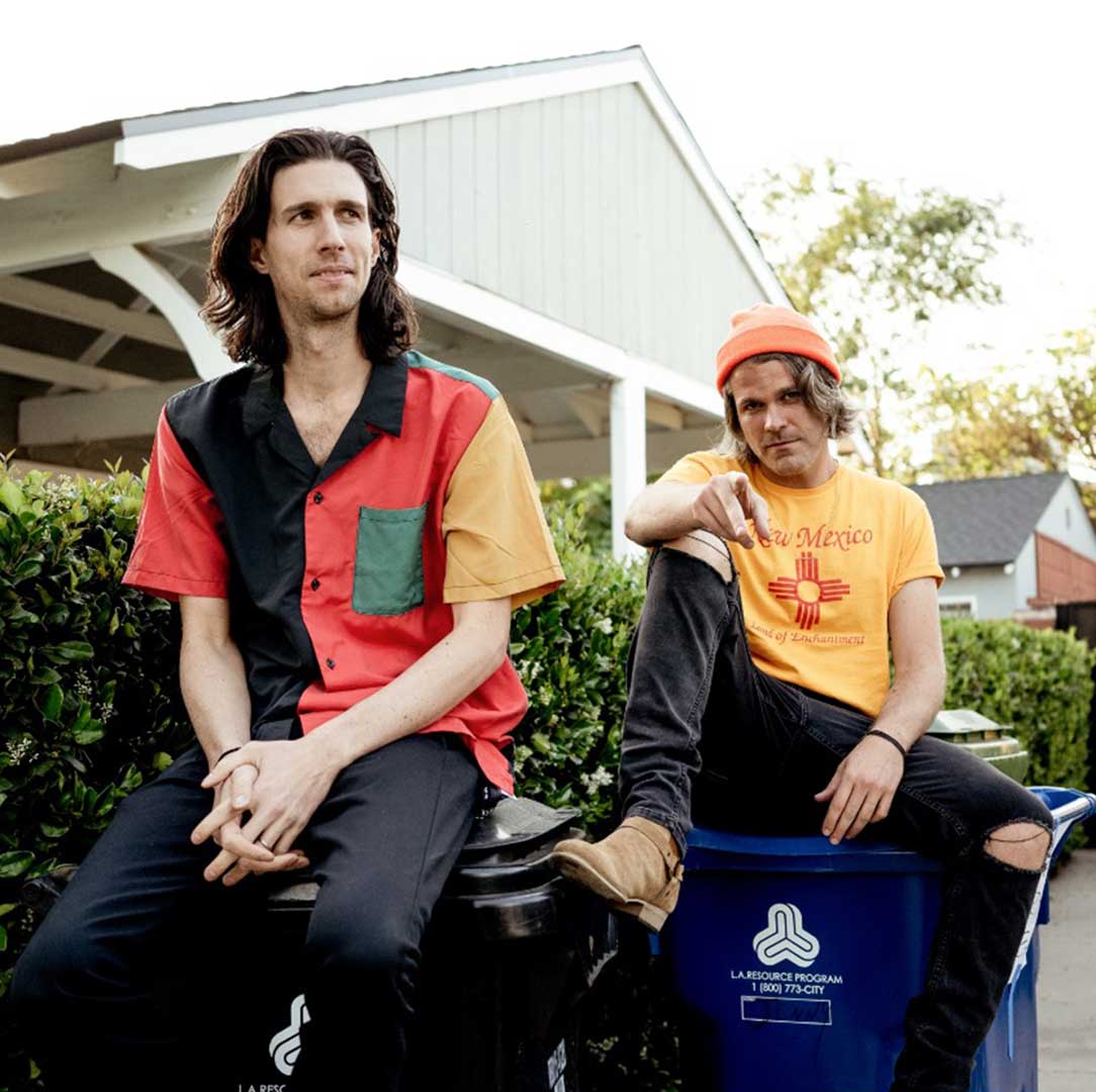 Members of 3OH!3 pose on recycling bins