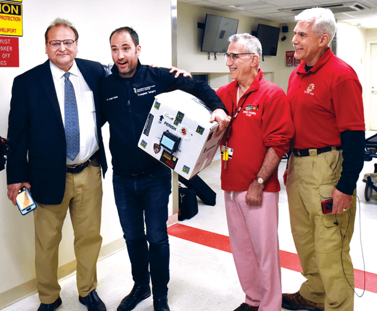 Dr. Joseph Scalea holds the kidney, flanked by Norman Wereley, chair of the Department of Aerospace Engineering; Dr. Thomas Scalea, physician in chief at the R Adams Cowley Shock Trauma Center (and uncle to Joseph Scalea); and Matt Scassero, UAS Test Site director.