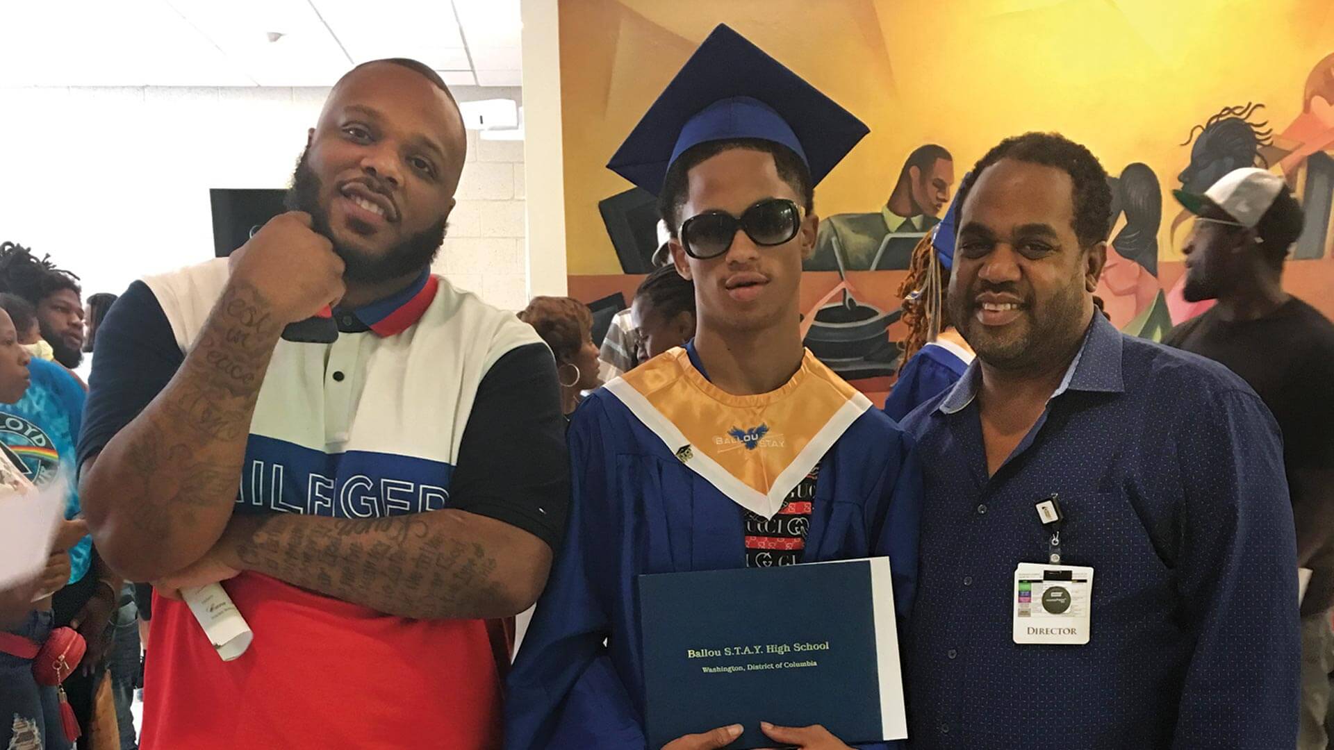 Richardson and Bullock stand with Majhe Powers, center, at his high school graduation. 