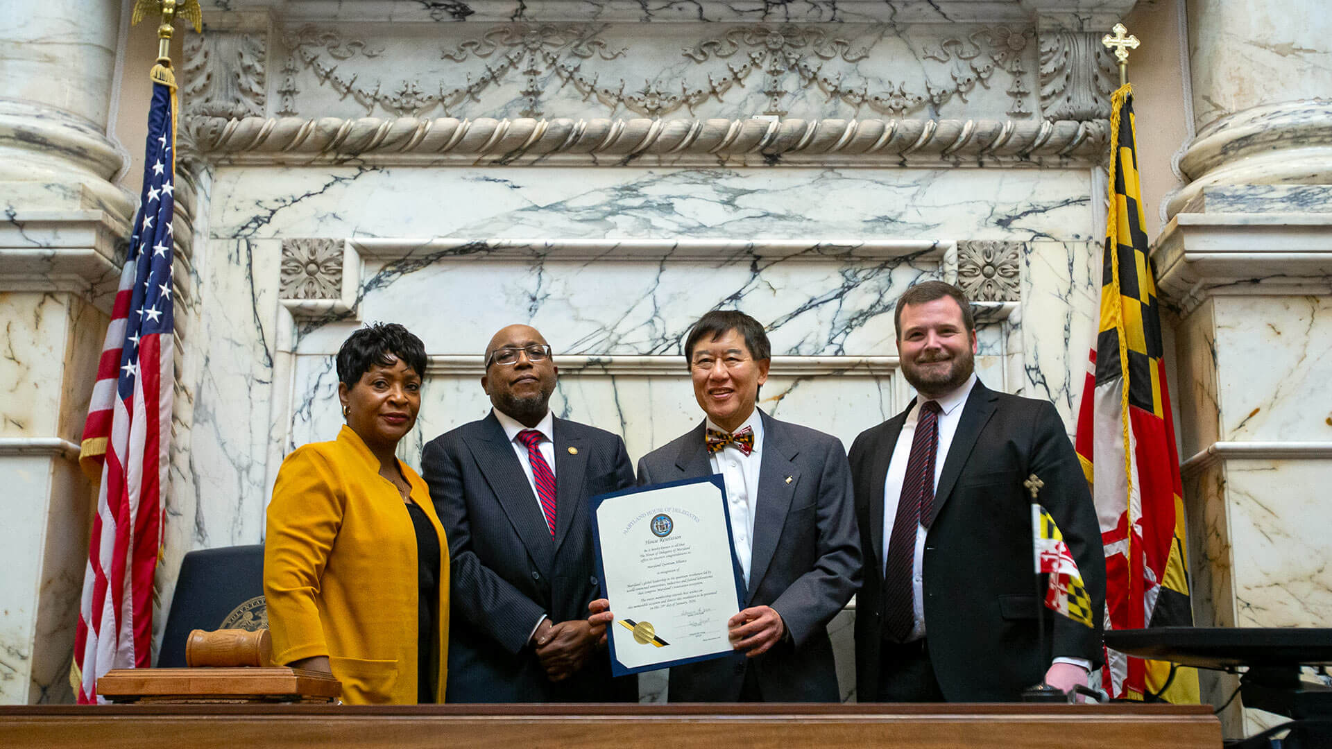 At the Maryland statehouse, UMD President Wallace D. Loh holds a proclamation recognizing the alliance. From left, House Speaker Adrienne A. Jones, Morgan State University President Willie May Ph.D. '77, and Baltimore County Del. Pat Young look on.