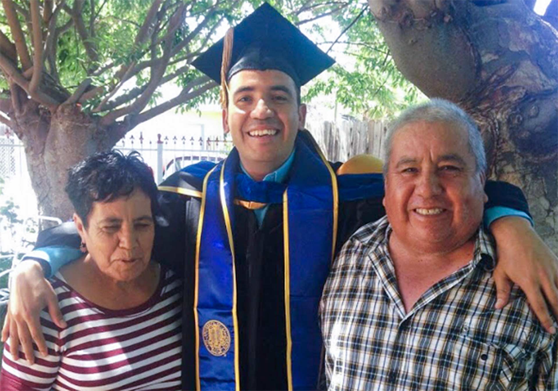 Gutierrez stands with his parents at his doctoral graduation ceremony at the University of California, Davis.