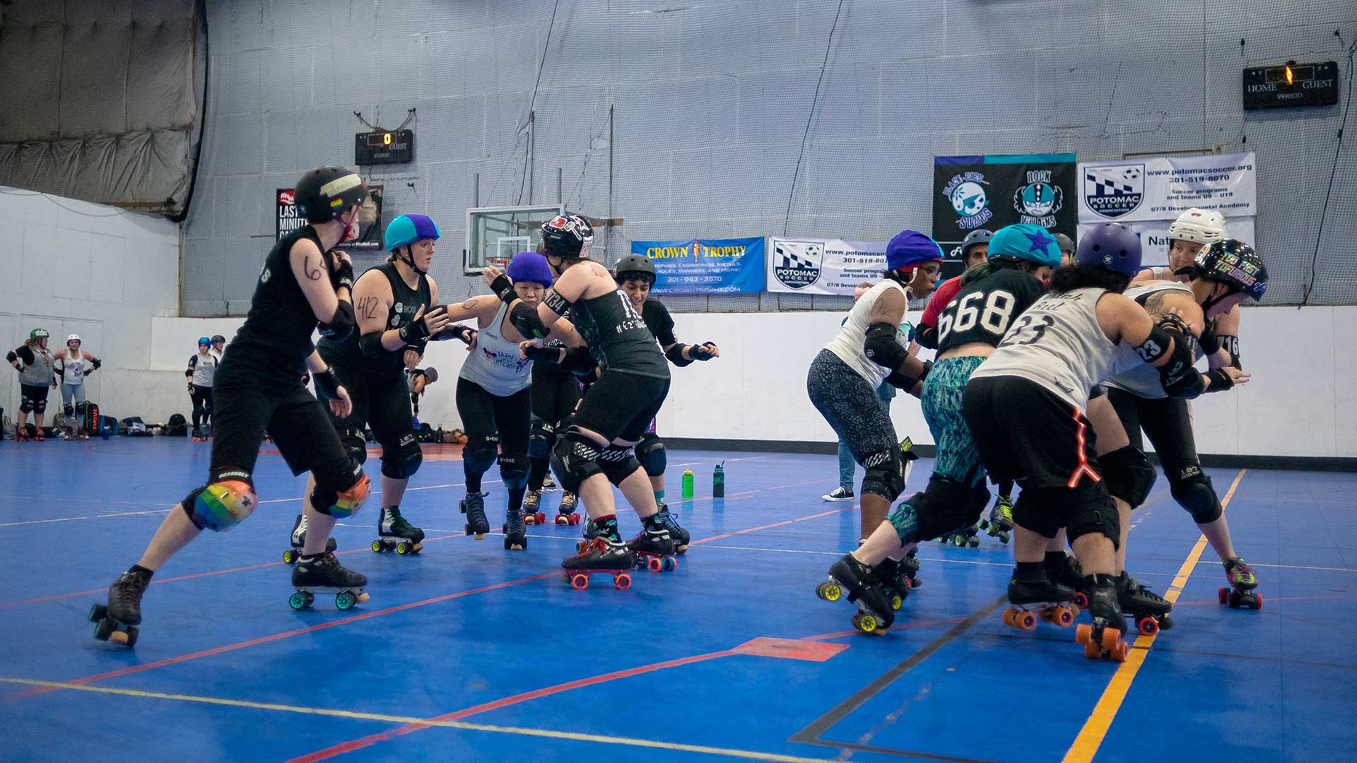 AnnaHell Lee #412 (second to the left, striped helmet) serving as the pivot of the jam attempts to block a jammer during a scrimmage at practice at Michael & Son Sportsplex at Rockville on Friday, September 20, 2019.