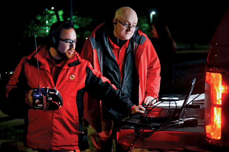 Drone pilot Ryan Henderson (left) and Tony Pucciarella, former director of operations at the UAS Test Site, watch the progress of the first flight to carry an organ to a patient by unmanned aircraft.