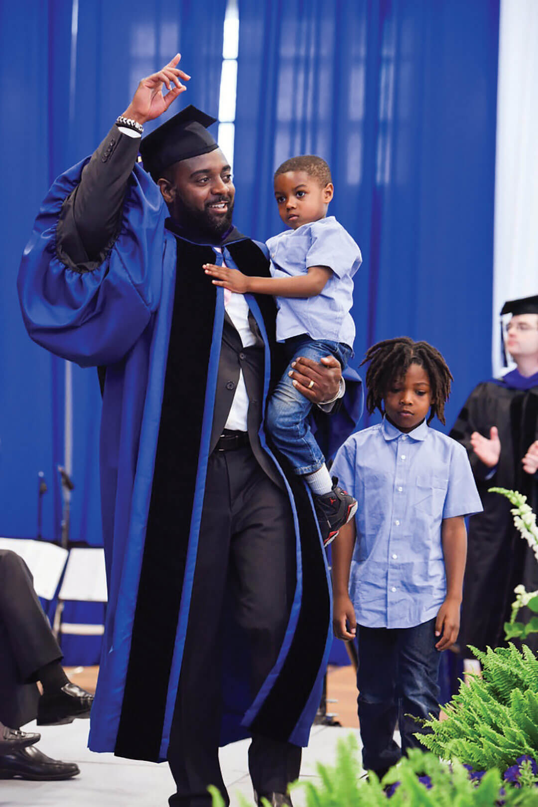 Reginald Dwayne Betts walks across the stage at graduation